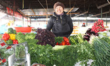 Woman standing at a vegetable stall at market