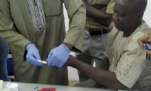A health worker uses a hemocue on a patient.