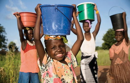 Children carry buckets of water on their heads.