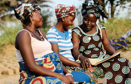 Three women smile together in Sierra Leone.