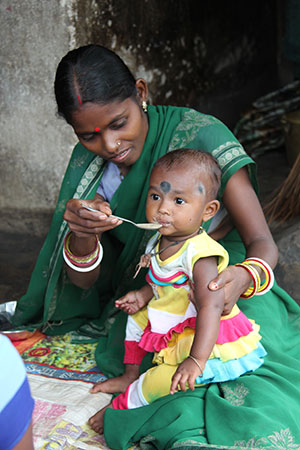 An Indian woman feeds her young child