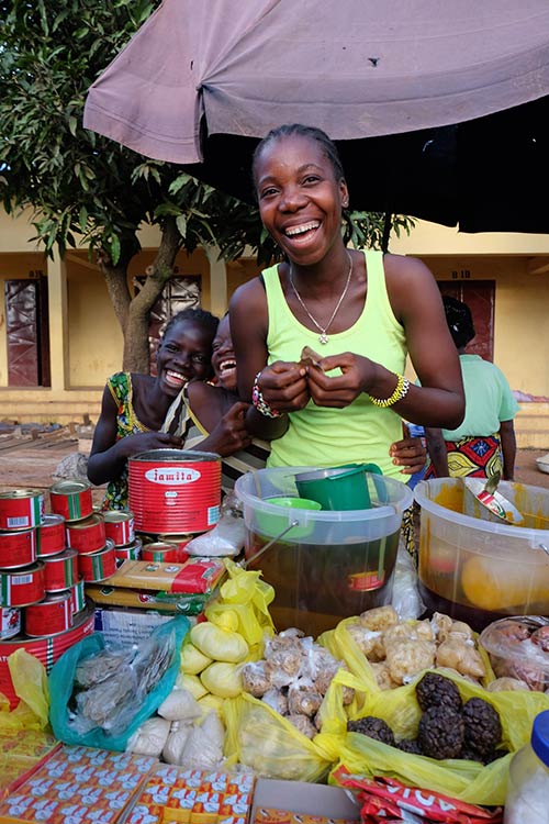A female entrepreneur in Sierra Leone smiles at the camera.