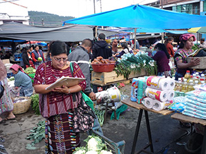 woman with a clipboard walking through a market
