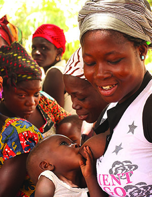 Photo of a group of women, one of whom is breastfeeding her child.