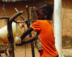 Photo of a young boy using a tippy tap.
