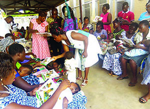 Photo of mothers and children reading through support and health materials.