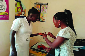 Photo of two female healthcare workers demonstrating anemia testing.