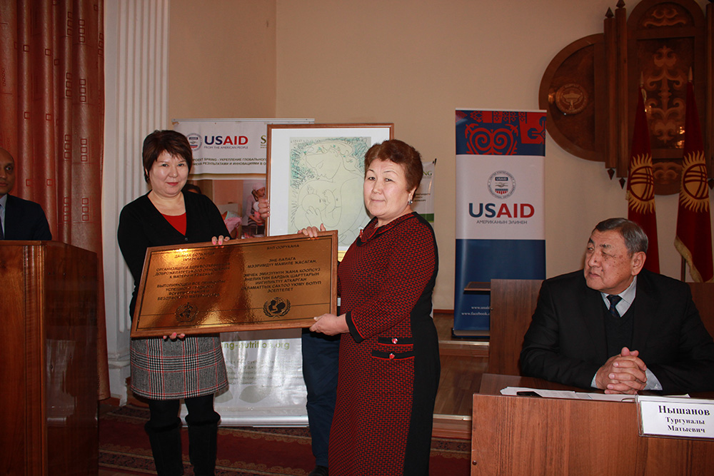The Deputy Director of Ala-Buka FMC, Jumagul Tazhibaeva, accepts the BFHI certification plaque. 