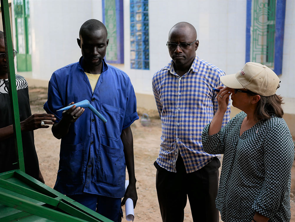 A community-based service provider shows USAID staff the agricultural tool that he created after attending a training on the creation of small agricultural tools.