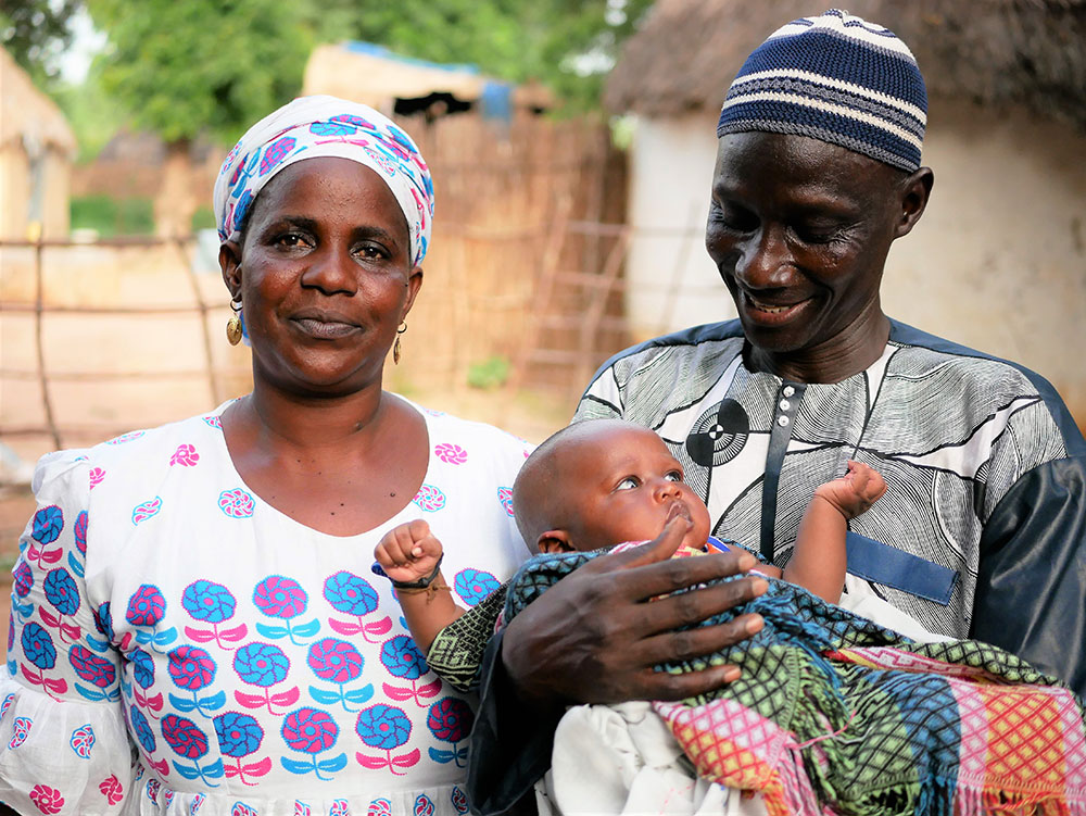A gender champion couple poses for a photo with their baby.