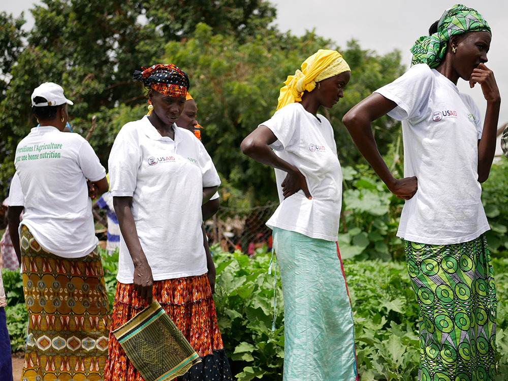 Members of a women’s group inspect the state of their community garden.