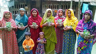 Image of FNS participants displaying vegetable seedlings they received to plant in their gardens.