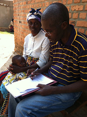 health worker collecting data from woman with young child