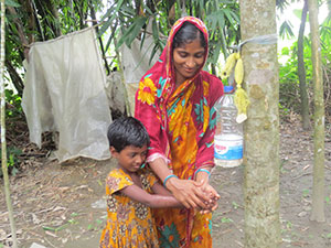 Woman and child washing hands using a Tippy Tap,
