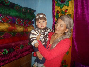 Rural mother Seitova Raima and her eight-month-old son benefitted from USAID-supported trainings in infant and young child feeding practices.