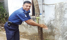 Officer Faridul Islam washes his hands with a tippy tap.