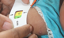 A Family Welfare Visitor uses mid-upper arm circumference (MUAC) tape to regularly screen the growth of children in her area.