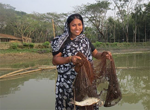 Photo of a woman holding a fishing net in a pond