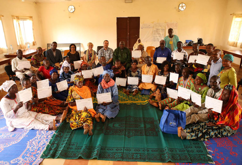 Photo of a room of people receiving MIYCN training certificates in Guinea