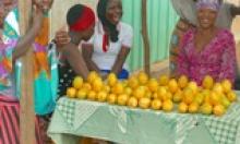 Women sell oranges in a road side market in Ghana. 