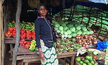 Woman stands in front of produce stand