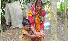 Woman and child washing hands using a Tippy Tap.