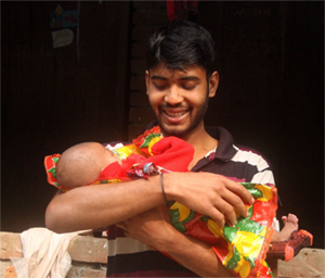 Photo of smiling Jewel holding his baby