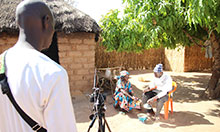 Two community members being filmed eating a delicious meal containing orange-fleshed sweet potato. 