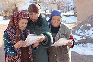 Photo of three women looking at the toolkit materials. 